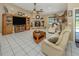 Bright living room with tile flooring, stone fireplace, ceiling fan, and comfortable seating at 2331 Mission Valley Blvd, Nokomis, FL 34275