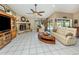 Bright living room featuring tile flooring, a stone fireplace, and comfortable seating at 2331 Mission Valley Blvd, Nokomis, FL 34275