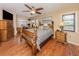 Charming main bedroom boasts hardwood floors, a ceiling fan, and a view of the desk and chair at 2331 Mission Valley Blvd, Nokomis, FL 34275