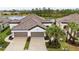 Stunning aerial view of a modern home with a tile roof, two-car garage, and a serene lake backdrop at 249 Tracino Ter, Nokomis, FL 34275