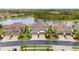 Expansive aerial view showcasing modern homes with tile roofs, well-manicured lawns, and a peaceful lake setting at 249 Tracino Ter, Nokomis, FL 34275