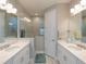 Elegant bathroom with double sinks, quartz countertops, and a spacious walk-in shower enclosed in glass at 249 Tracino Ter, Nokomis, FL 34275