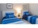 Cozy bedroom featuring two twin beds with blue striped bedding, complemented by beach-themed decor at 249 Tracino Ter, Nokomis, FL 34275