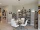 Charming dining area with a glass table, white chairs, and decorative shelving featuring nautical-themed decor at 249 Tracino Ter, Nokomis, FL 34275