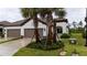 Charming single-story home featuring a tile roof, landscaped front yard with palm trees, and a two-car garage at 249 Tracino Ter, Nokomis, FL 34275