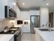 Well-equipped kitchen with stainless steel appliances, white cabinets, subway tile backsplash, and quartz countertops at 249 Tracino Ter, Nokomis, FL 34275