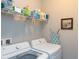 Practical laundry room with modern LG washer and dryer, storage shelving, and ironing board at 249 Tracino Ter, Nokomis, FL 34275