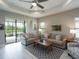 Inviting living room with sliding glass doors to patio and serene lake views, enhancing the natural light at 249 Tracino Ter, Nokomis, FL 34275
