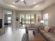 Comfortable living room with patio access and views of the serene lake, with an open doorway to the bedroom at 249 Tracino Ter, Nokomis, FL 34275