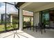 Covered patio with outdoor seating offers a shaded area for relaxation and views of the lush backyard at 249 Tracino Ter, Nokomis, FL 34275