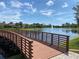 Scenic view of community pond from wooden bridge with fountain and surrounding lush greenery at 249 Tracino Ter, Nokomis, FL 34275
