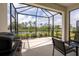 Relaxing screened lanai with seating area, grill and peaceful views of the backyard pond at 249 Tracino Ter, Nokomis, FL 34275
