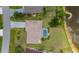 An aerial view of a home with a screened-in pool, landscaping, and close proximity to a lake at 25509 Arequipa Dr, Punta Gorda, FL 33983