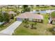 Aerial view showcasing the home's layout, manicured lawn, and spacious driveway in a serene neighborhood at 25509 Arequipa Dr, Punta Gorda, FL 33983