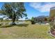 Expansive backyard with a view of the lake, featuring a screened-in pool area, and mature trees at 25509 Arequipa Dr, Punta Gorda, FL 33983