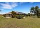 Wide shot of the home's backyard, featuring a pool, lush green lawn, and mature landscaping at 25509 Arequipa Dr, Punta Gorda, FL 33983