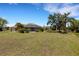 View of the home's spacious backyard with a screened-in pool and view of the nearby lake at 25509 Arequipa Dr, Punta Gorda, FL 33983