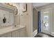 Well-lit bathroom with a vanity, a mirror, and a shower/tub combo with a door to the patio at 25509 Arequipa Dr, Punta Gorda, FL 33983