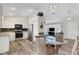 Open dining area, with kitchen access, featuring wood floors and contemporary lighting at 25509 Arequipa Dr, Punta Gorda, FL 33983