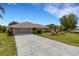 Attractive home featuring a long driveway, screened garage, and well-maintained front yard at 25509 Arequipa Dr, Punta Gorda, FL 33983
