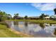 Scenic view of the lake behind the home, surrounded by lush greenery and neighboring houses at 25509 Arequipa Dr, Punta Gorda, FL 33983