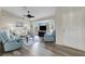 Bright living room with large windows, vaulted ceilings, ceiling fan, and hardwood floors at 25509 Arequipa Dr, Punta Gorda, FL 33983