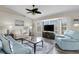 Bright living room with large windows, vaulted ceilings, ceiling fan, and hardwood floors at 25509 Arequipa Dr, Punta Gorda, FL 33983