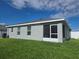 View of the back of the home showcasing a screened in patio and a well maintained lawn with a white privacy fence at 3003 58Th E Way, Palmetto, FL 34221