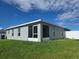 View of the back of the home showcasing a screened in patio and a well maintained lawn with a white privacy fence at 3003 58Th E Way, Palmetto, FL 34221