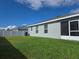 View of the back of the home showcasing a screened in patio and a well maintained lawn with a white privacy fence at 3003 58Th E Way, Palmetto, FL 34221