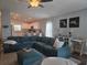 Open-concept living room featuring a teal sectional sofa and seamless flow to a modern kitchen at 3003 58Th E Way, Palmetto, FL 34221