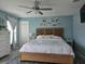 Serene main bedroom with a wooden bed frame, soft blue walls, and a collection of framed pictures at 3003 58Th E Way, Palmetto, FL 34221