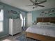 Bright main bedroom features a wooden bed frame, blue accent wall, and large windows with sheer curtains at 3003 58Th E Way, Palmetto, FL 34221