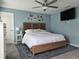 Bright main bedroom with a wooden bed frame, side tables, and soft blue walls at 3003 58Th E Way, Palmetto, FL 34221