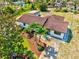Aerial view showcases a home with a terracotta roof, palm trees, and a green lawn at 301 Gulf Dr, Venice, FL 34285