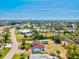 Expansive aerial view showcases a charming home nestled in a community with lush landscaping and serene water views beyond at 301 Gulf Dr, Venice, FL 34285