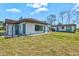 View of a spacious backyard with a white home and shed featuring a red tile roof at 301 Gulf Dr, Venice, FL 34285