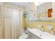 Bright bathroom featuring yellow tiles, a shower with curtain, and a sink with a medicine cabinet at 301 Gulf Dr, Venice, FL 34285