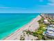 Beautiful aerial image showcases the beachfront near residential homes, highlighting the proximity to the ocean and the sandy shoreline at 301 Gulf Dr, Venice, FL 34285