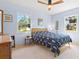 Light and airy bedroom features pale blue walls, a ceiling fan, and two windows offering serene outdoor views at 301 Gulf Dr, Venice, FL 34285