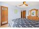 Spacious bedroom with light blue walls, ceiling fan, wood furniture, and a comfortable bed with a patterned comforter at 301 Gulf Dr, Venice, FL 34285