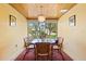 Cozy dining room features wood ceiling, modern chandelier, and a large window with a beautiful outdoor view at 301 Gulf Dr, Venice, FL 34285