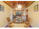 Charming dining room with wood ceiling, decorative chandelier, and direct access to the living room at 301 Gulf Dr, Venice, FL 34285