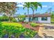 Charming single-story home boasts lush landscaping with vibrant plants, enhancing its curb appeal and welcoming ambiance at 301 Gulf Dr, Venice, FL 34285