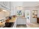 This well lit kitchen has white cabinets, a wooden countertop, and a view to the back yard at 301 Gulf Dr, Venice, FL 34285