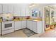 Bright kitchen featuring white cabinets, a wood countertop, with an inviting view to the outside at 301 Gulf Dr, Venice, FL 34285