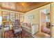 Comfortable living room features a patterned chair and sofa, bright natural light, and a wood plank ceiling at 301 Gulf Dr, Venice, FL 34285