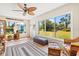 Inviting sunroom featuring large windows with views of the backyard, natural light and stylish decor at 301 Gulf Dr, Venice, FL 34285
