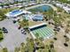 Aerial view of a community pool, shuffleboard court and clubhouse surrounded by palm trees and ample parking at 304 Roma Rd, Venice, FL 34285