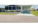 Charming home featuring a covered carport, front porch with an enclosed sunroom, and manicured landscaping at 304 Roma Rd, Venice, FL 34285